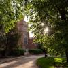 Campus building framed by green trees in the summer
