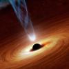 Matter swirls around a central black hole as it emits a bright jet