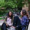Two women sit on a bench on the CU Boulder campus.