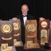 CU Skiing Coach Richard Rokos, standing with his NCAA Championship trophies