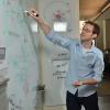 Computer Engineering Professor Aaron Clauset writes on white board