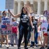 Protesters carry signs outside the Supreme Court