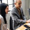 Co-workers look at a computer screen