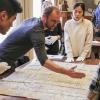 Librarian Adam Lisbon and students look through archives