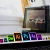 Person scrolls through Mac toolbar to open Adobe Photoshop