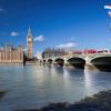 Stock image of double decker red buses on a bridge with Big Ben clock tower in the background