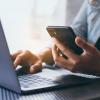 person checking mobile phone and laptop