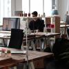 Person sits at desk in open-floor office