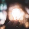 person holding an illuminated lightbulb