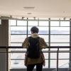 Person looks out window at airport