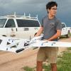 CU Boulder researcher holds drone with storm moving in