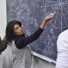 A faculty member demonstrates an applied mathematics lesson using a chalkboard.