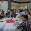 People in small groups discuss at round tables. 