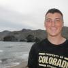 Austin Riley stands in his black CU football shirt on the beach on the coast of Spain.
