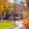 Student walks on campus with fall colors