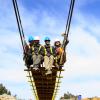 CU Boulder engineering students sit on suspension bridge