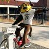 Chip posing on a B-cycle at a station on campus
