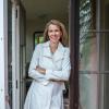 Beth Osnes leans against a glass door