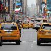 Taxies drive down a crowded city street