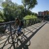 Woman bikes to work, with 28th Street apartments in background