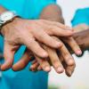 Circle of people put their hands together