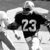 Black and white photo of Cliff Branch running football