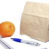 A brown bag, orange and notepad with pen