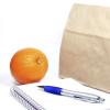 Brown bag, pen, notepad and orange