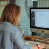 woman sits at desktop computer