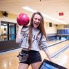 A student poses with a bowling ball at The Connection on campus
