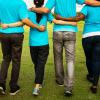 Group of people walk arm in arm