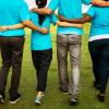 Group of in teal shirts walking arm in arm