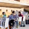 students working on laptops sitting at tables outside