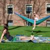 Students lounging on a hammock campus in the summertime