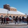 students walk across a snowy campus