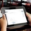 Person checks Canvas course on ipad in coffee shop