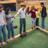 A group participates in an indoor challenge experience.
