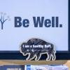 A Be Well sign on a table at a CU Boulder event.
