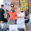 Students hold up a red X, of the TEDx logo, at an involvement fair booth