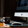 Coffee and notebook at desk with iMac