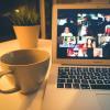 Zoom webinar on a laptop next to a cup of coffee