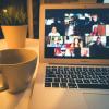 Video conference on a laptop with a cup of coffee on the desk