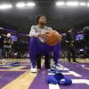 Basketball player sits on the court 