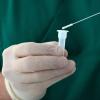 A gloved hand holds a Covid test
