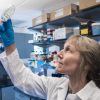 Professor Corrie Detweiler holding up a lab sample to the light