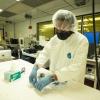 Engineer wearing a mask and cap working in cleanroom at COSINC