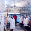Researchers pose in their lab behind glass with the words "COVID Warriors" written on it.