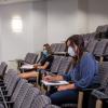 students physically distance in large lecture hall