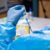 doctor prepares a vial of the Moderna COVID-19 vaccine