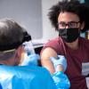 Richard Biggs, 20, an evolutionary biology major at CU Boulder, gets his first dose of the Moderna vaccine from Dr. Laird Wolfe. (Photo by Glenn Asakawa/University of Colorado)